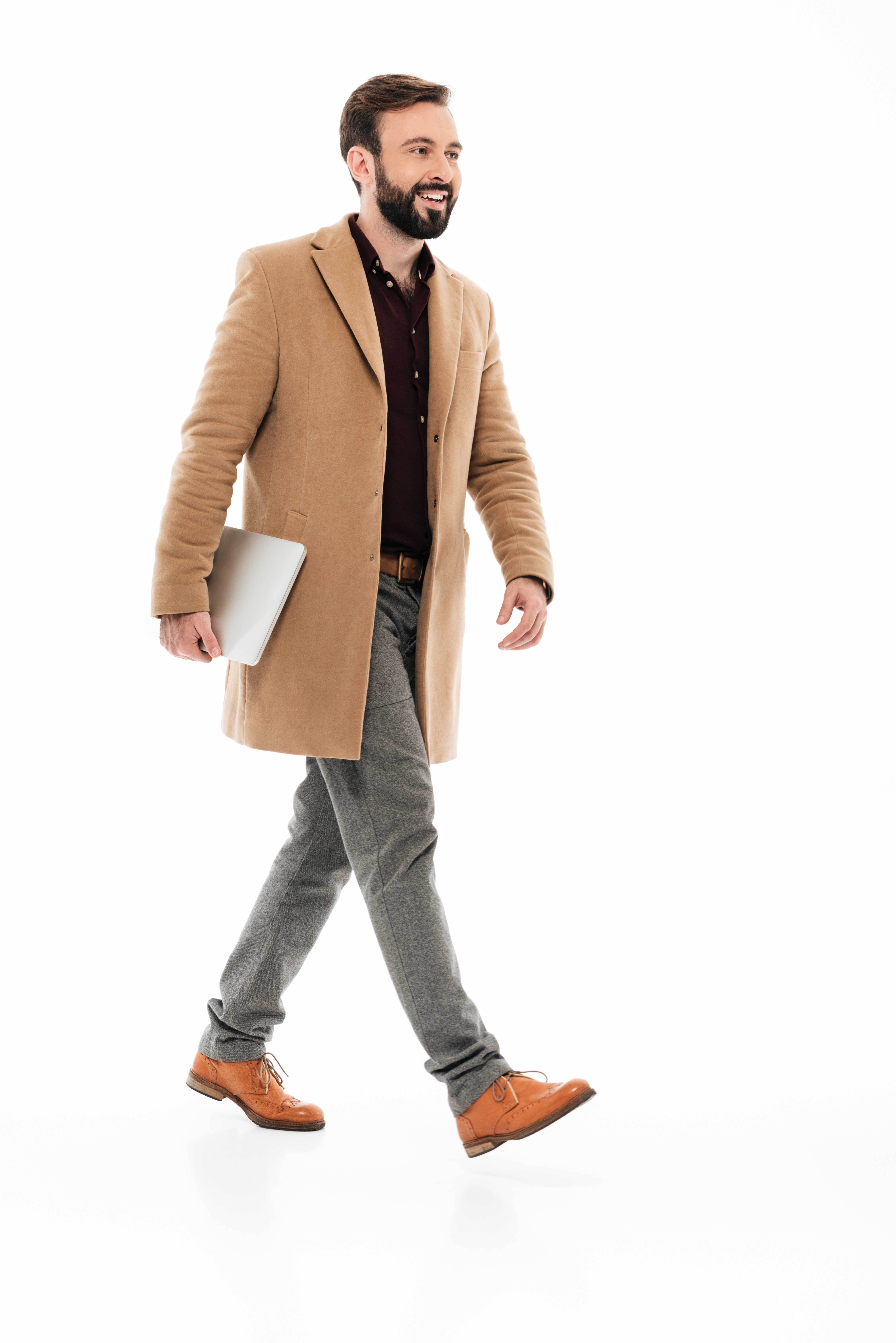 Homem elegante de terno marrom, com notebook em uma das mãos.